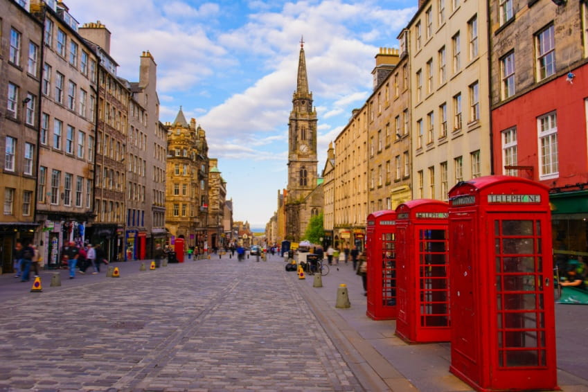 Bustling Royal Mile in Edinburgh Old Town with historic buildings, red phone boxes, and one Scots mile of history.