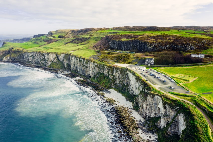 Aerial view of Larrybane Quarry showcasing Northern Ireland’s dramatic limestone cliffs and clear calm sea.